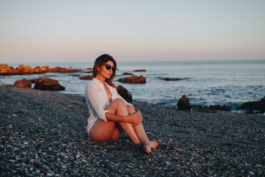 sunglasses lady sits on beach rubles