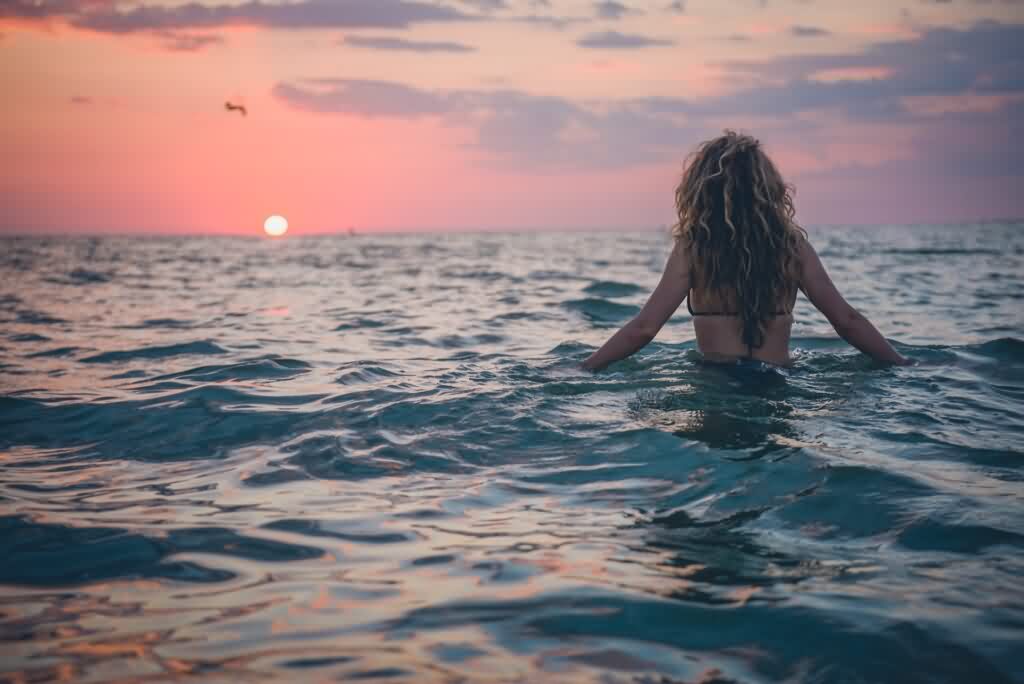 bikini laser hair removal girl walking down the beach in sunset