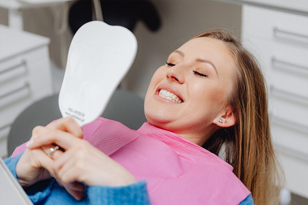 a woman shows her teeth in the mirror