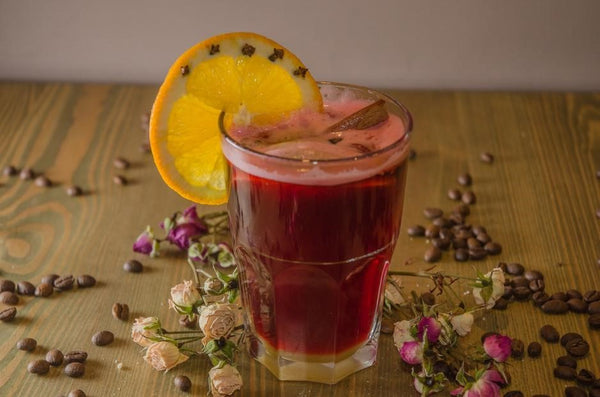 cup of mulled wine with a cut lemon on the rim of the cup