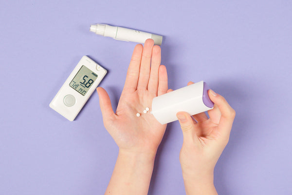 the woman is pouring the medicine, next to the blood sugar test kit