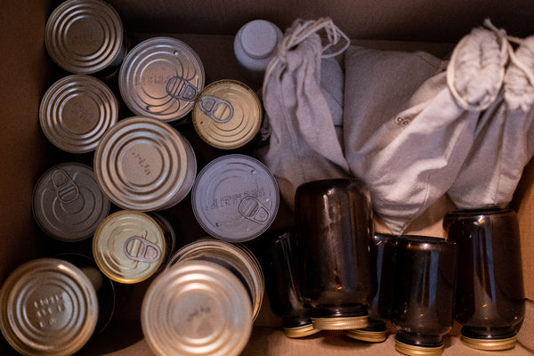 various cans and bottles stacked in boxes