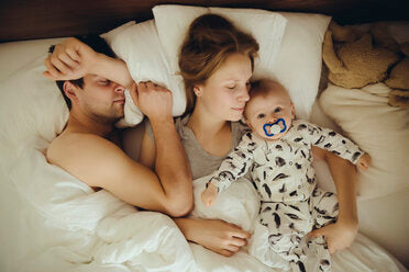 Mutter-Vater-und-Baby-Junge-kuscheln-im-Bett-MFF03643.jpg