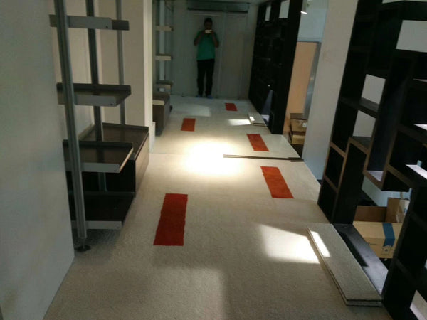 Matace removable plush carpet tiles in beige and orange line the hallway of one room.