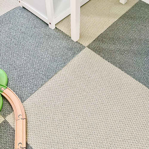 A girl's playroom is covered in gray and beige matace carpet squares.