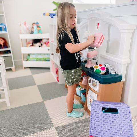 A young girl plays in a room covered with matace carpet.This room is her playroom, and the carpet is gray and beige!