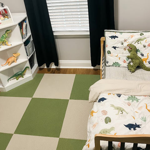 In a children's room with dinosaur toys, there is a Matace carpet sqares in green and cream.