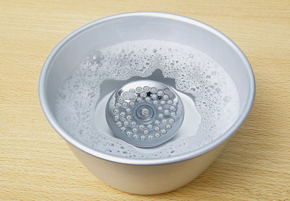 Chemical descaling method to clean shower head: soaking and scrubbing in all-purpose white vinegar