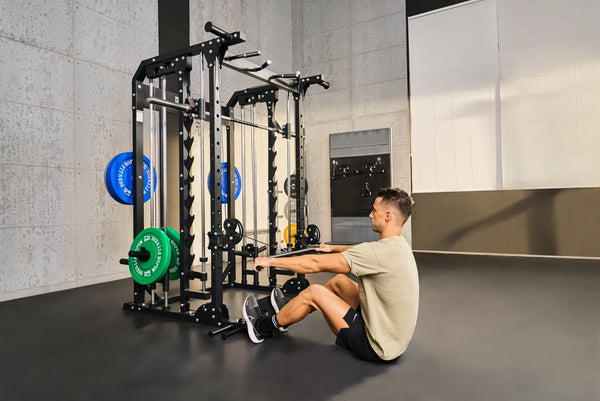 Man resting on a bench in front of a Smith machine