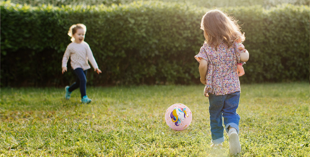 2 little kids playing soccer ball