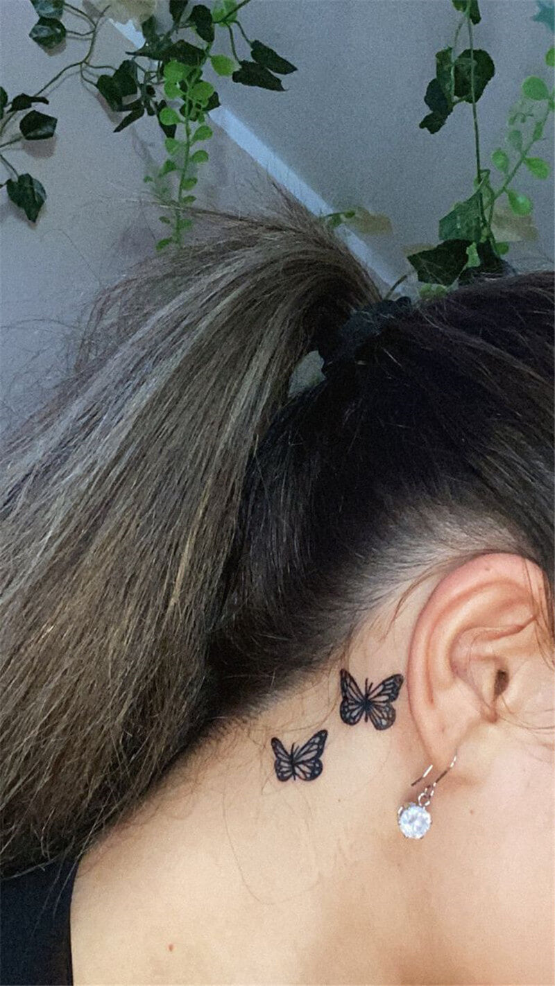 Black butterfly tattoo behind ear