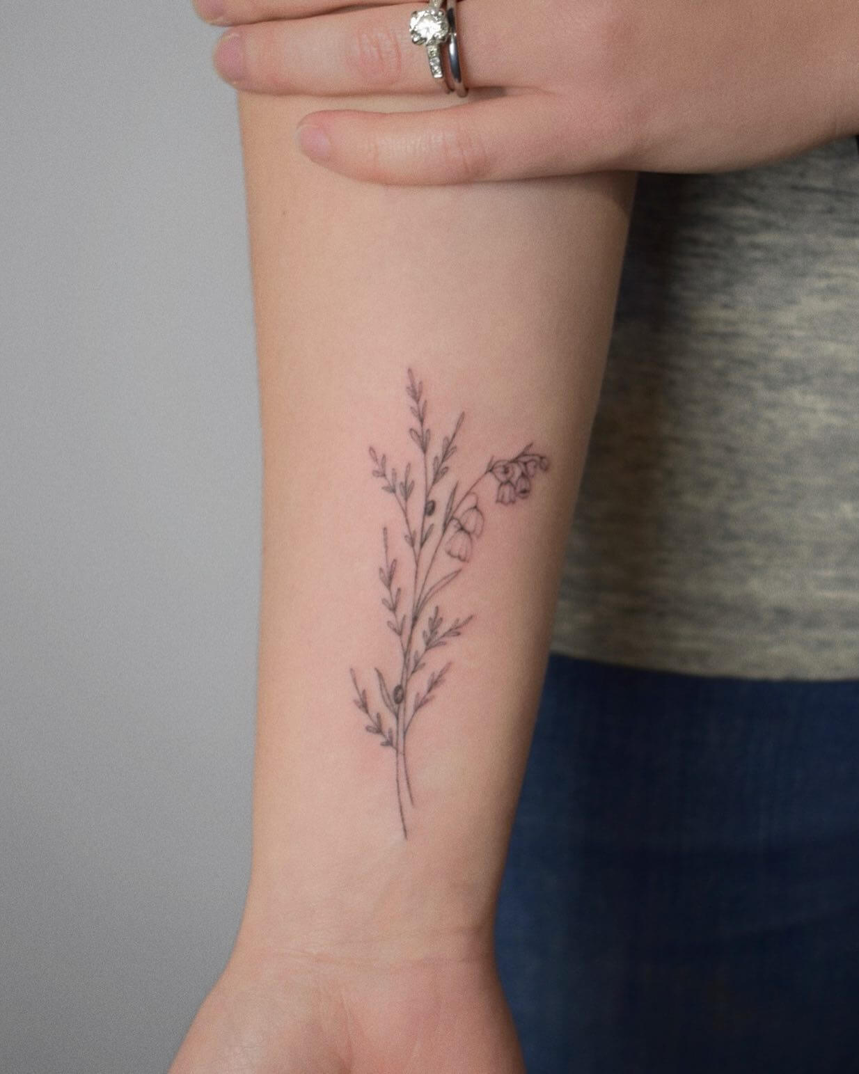Lily of the valley tattoo located on the inner forearm