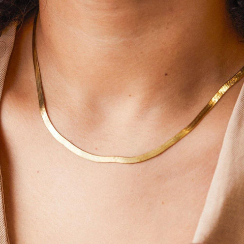 A person wear gold snake chain necklace.