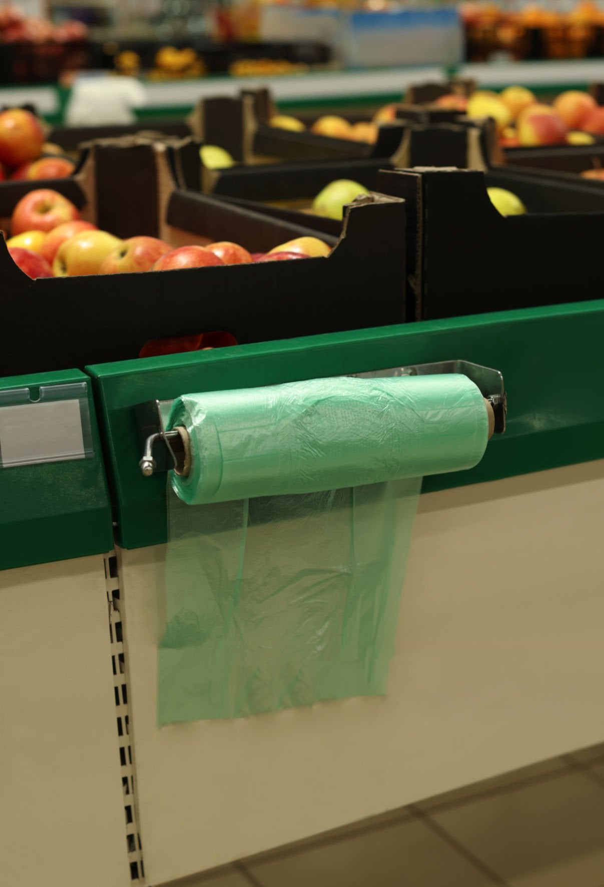 Compostable produce bags on roll with dispenser in grocery store