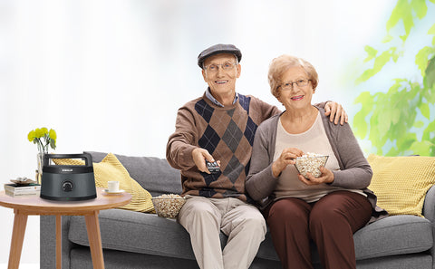 Two seniors is using SIMOLIO wireless portable speakers to watch TV