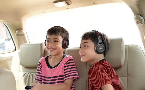 Two kids wear SIMOLIO wireless car headphones in a car