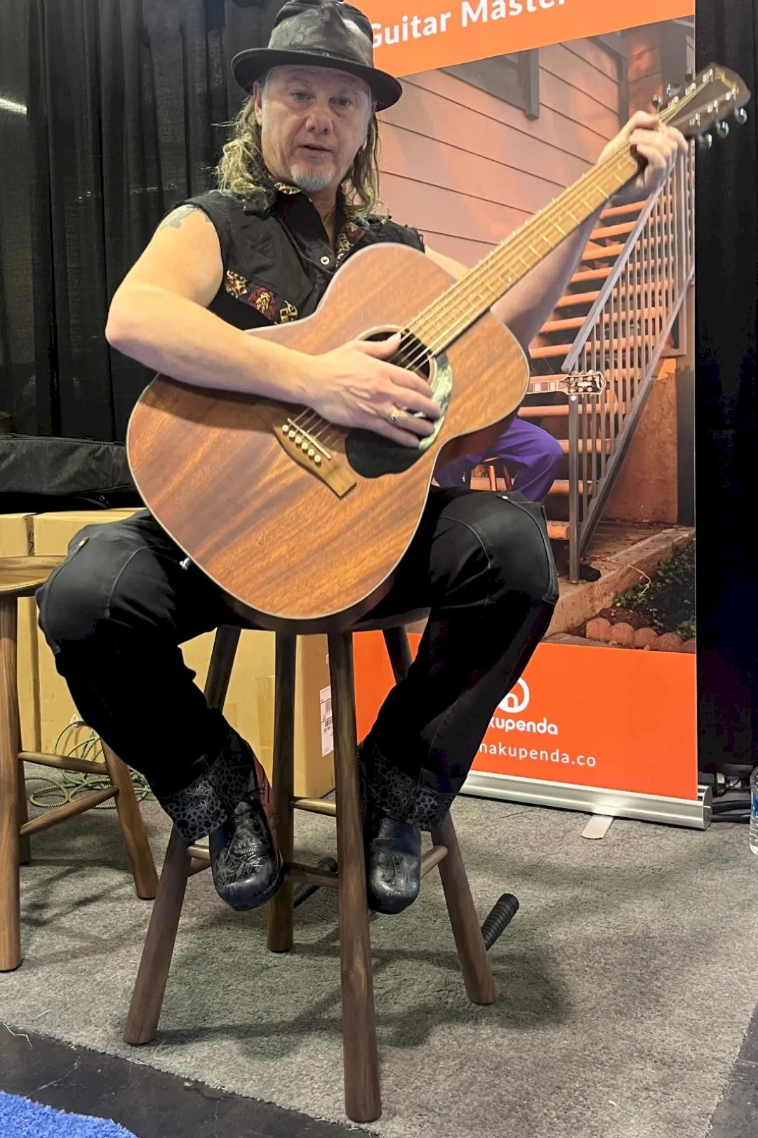 Editor of Guitar Player magazine, playing guitar while seated on guitar master stool