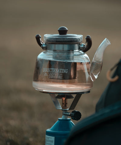 Another option is a small teapot, which is great for groups and provides a more authentic tea experience.   A camping stove or fire pit can be used to heat the water.
