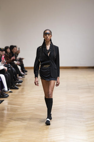 A girl walks in black and white saguaro beach shoes during Milan Fashion Week.