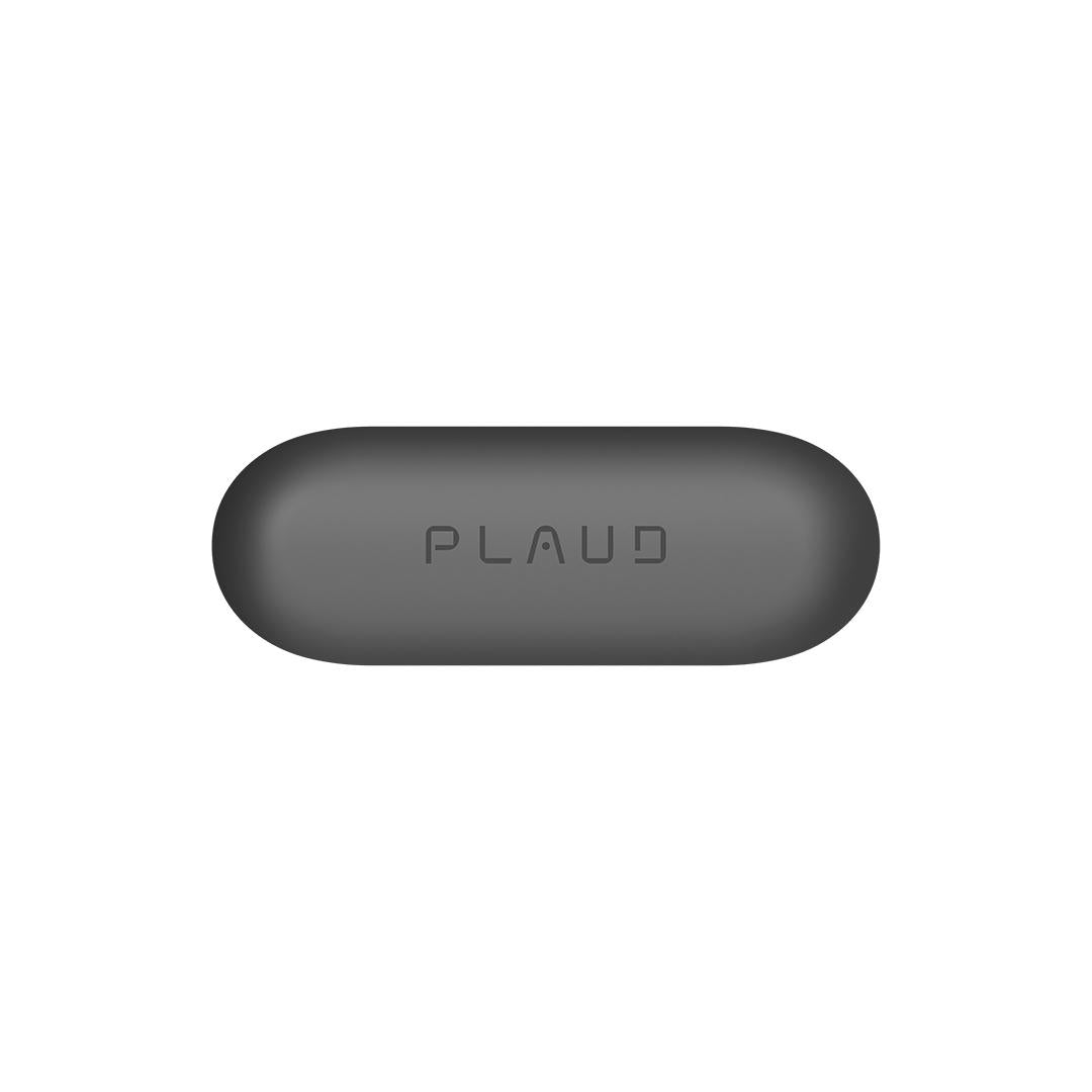A dark gray, pill-shaped Plaud AI voice recorder with the 'PLAUD' logo embossed on its surface is centered against a white ba