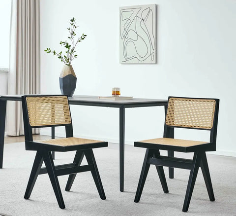 2 black wood cane chairs beside solid wood end table.