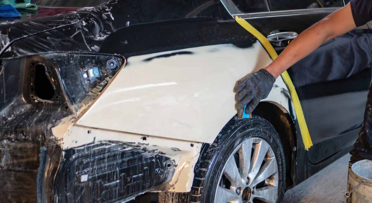 den Karosseriespachtel mit Schleifpapier abschleifen