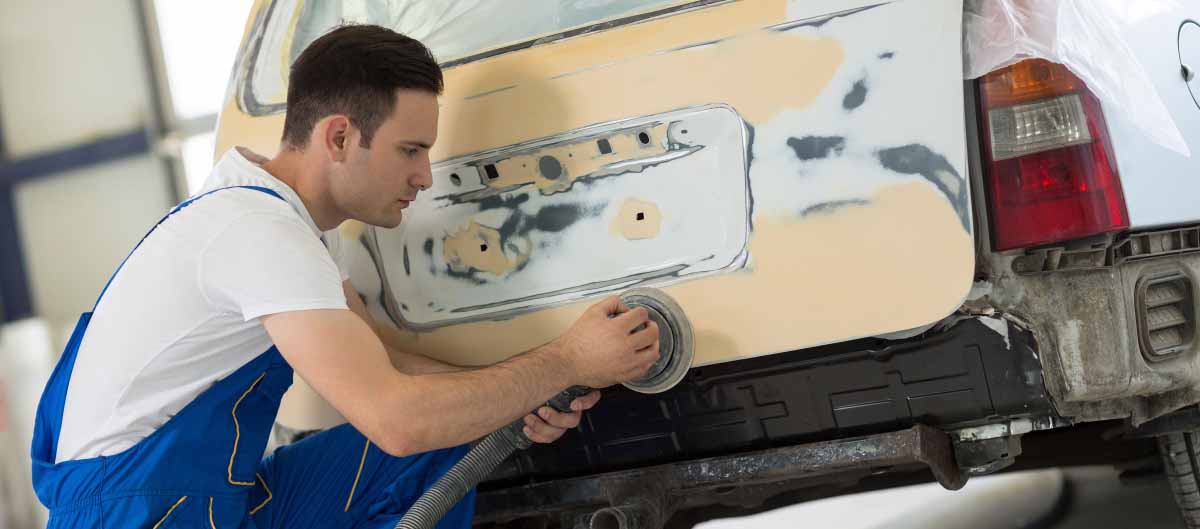 das Auto mit grobkörnigem Schleifpapier abschleifen