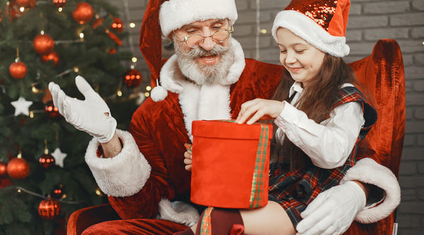 Der Weihnachtsmann gibt dem Kind Geschenke