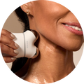 a photograph of a woman using the MINI+ device by NuFACE on her neck