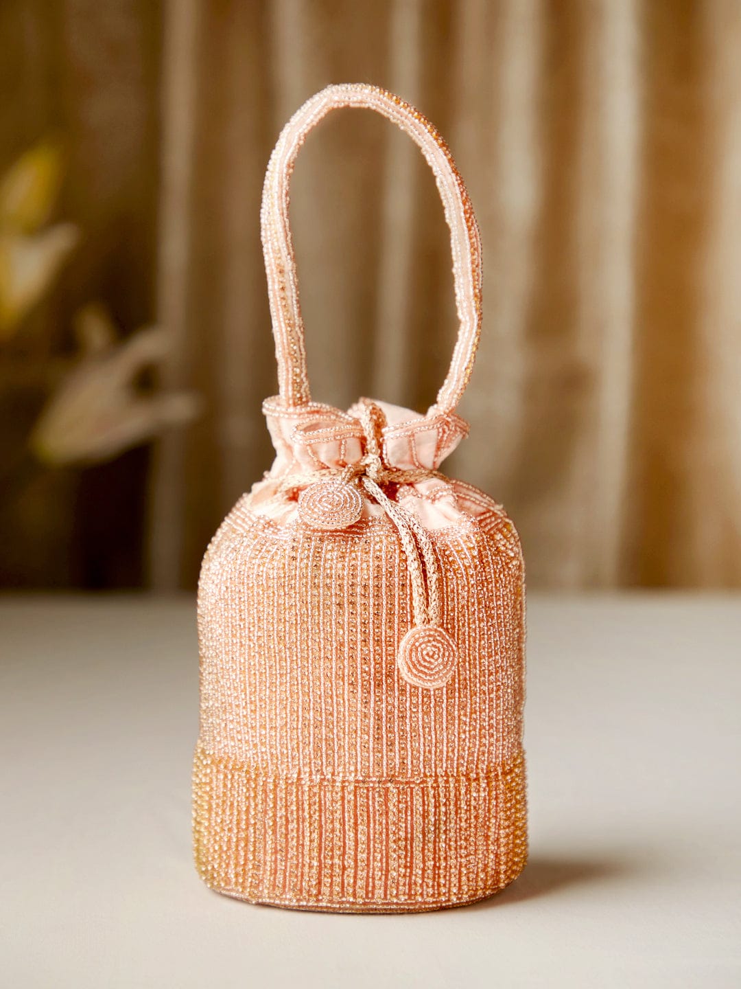 Rubans Peach Coloured Potli Bag With Golden Embroided Design.