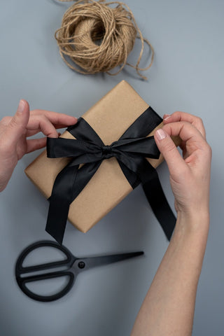 pack gift with wrapping paper and ties