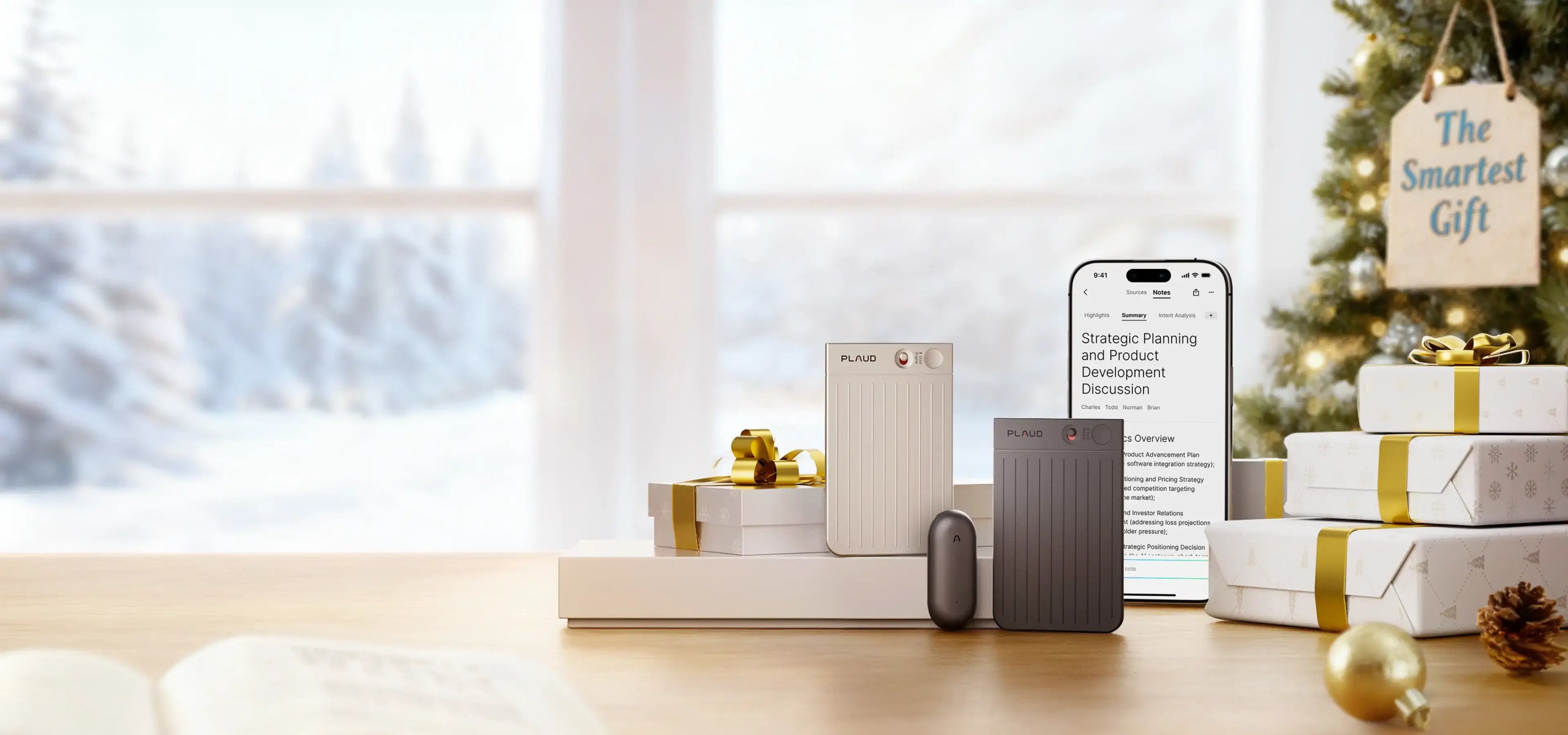 Silver and black Plaud Note Pro, black Plaud NotePin, and Plaud App on a phone in a festive holiday gift scene.