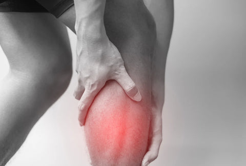A close-up of a person clutching their knee, highlighting the potential benefits of cold baths for reducing inflammation and pain relief.