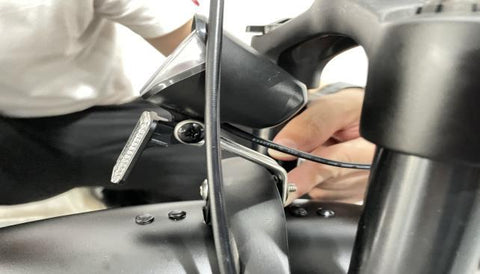 1. Alignez les trous des boulons du phare avec les trous du support de fourche.