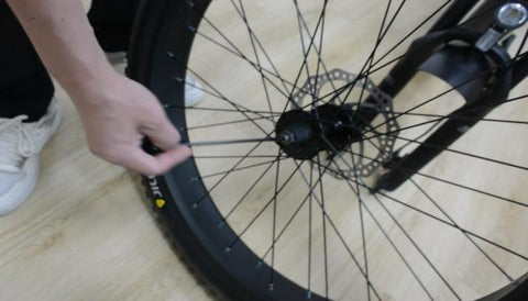Étape 2 : installez la brochette à dégagement rapide en commençant par le côté rotor de frein de la roue, en insérant la brochette à dégagement rapide à travers le moyeu, puis en remplaçant le deuxième ressort conique de l'autre côté. Assurez-vous que les deux ressorts sont pointés vers l'intérieur. vers le moyeu de roue.