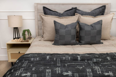 Charcoal Checkered Pillows and charcoal airplane patterned blanket on tan striped patterned zipper bedding
