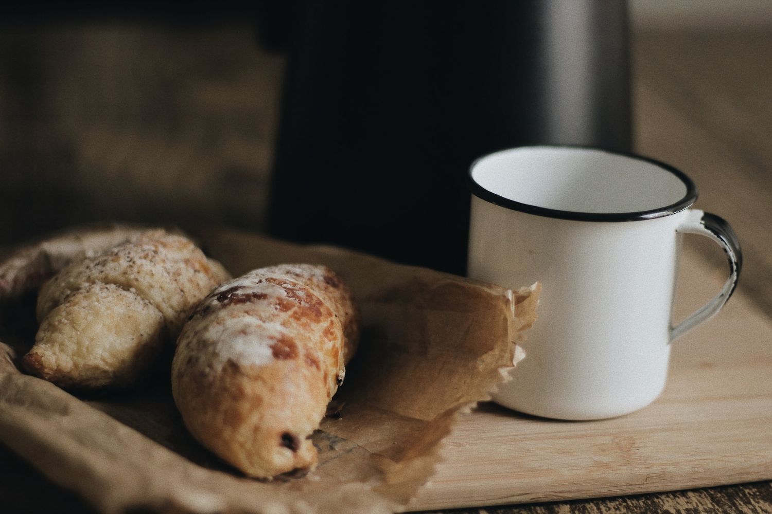 two bread on Baking paper beside a white cup