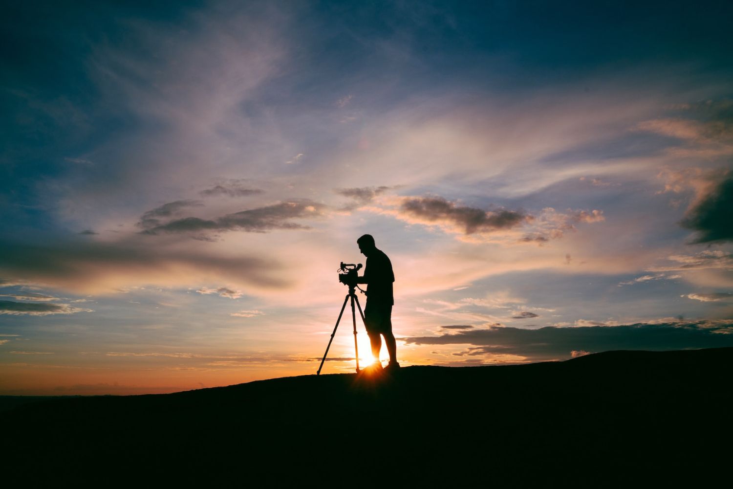 man standing and taking photo on sunset 