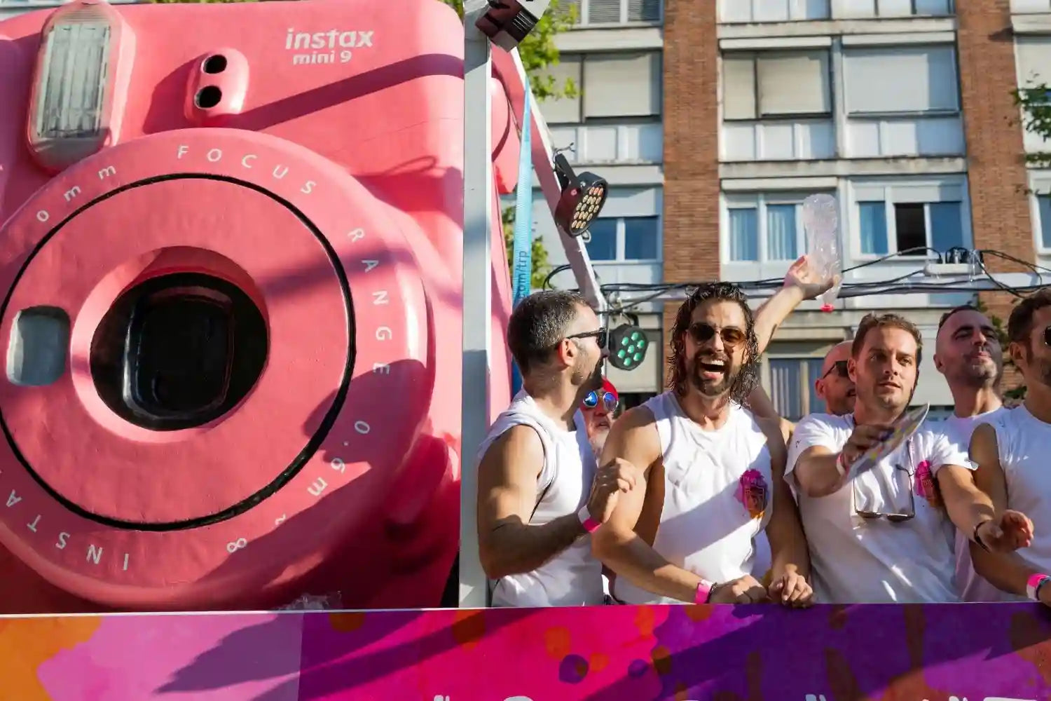 a big pink instax mini 9 and some smiling men 