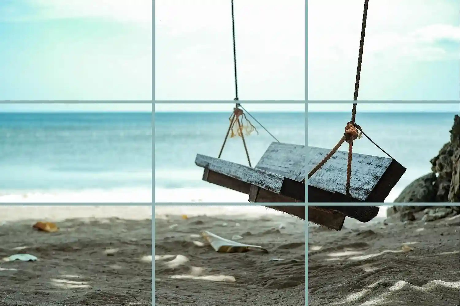 A wooden swing suspended on the beach