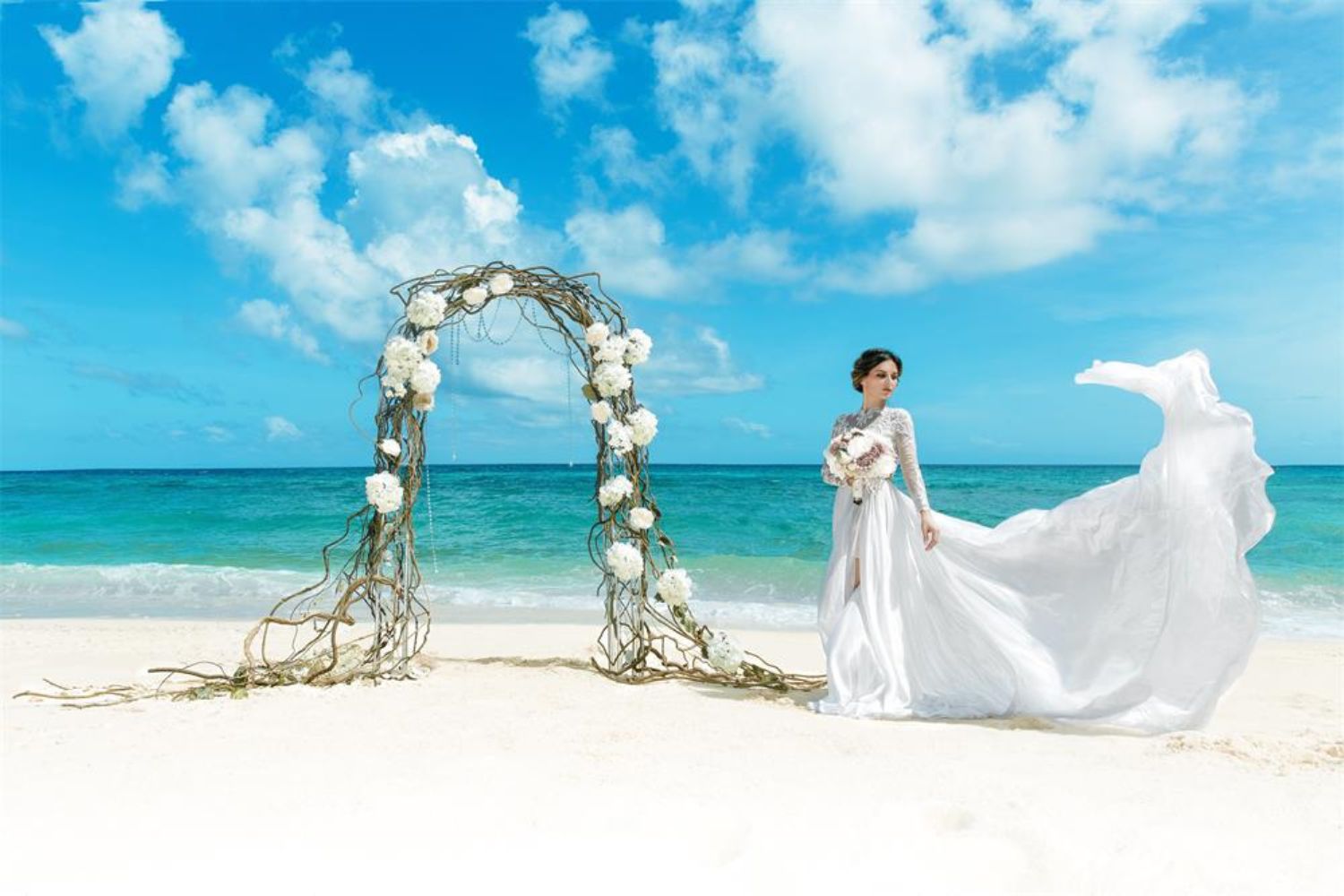 bride taking photo beside a flower arch