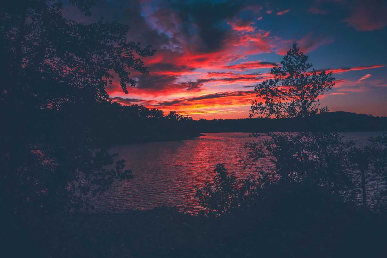sunset is reflected on the lake surface