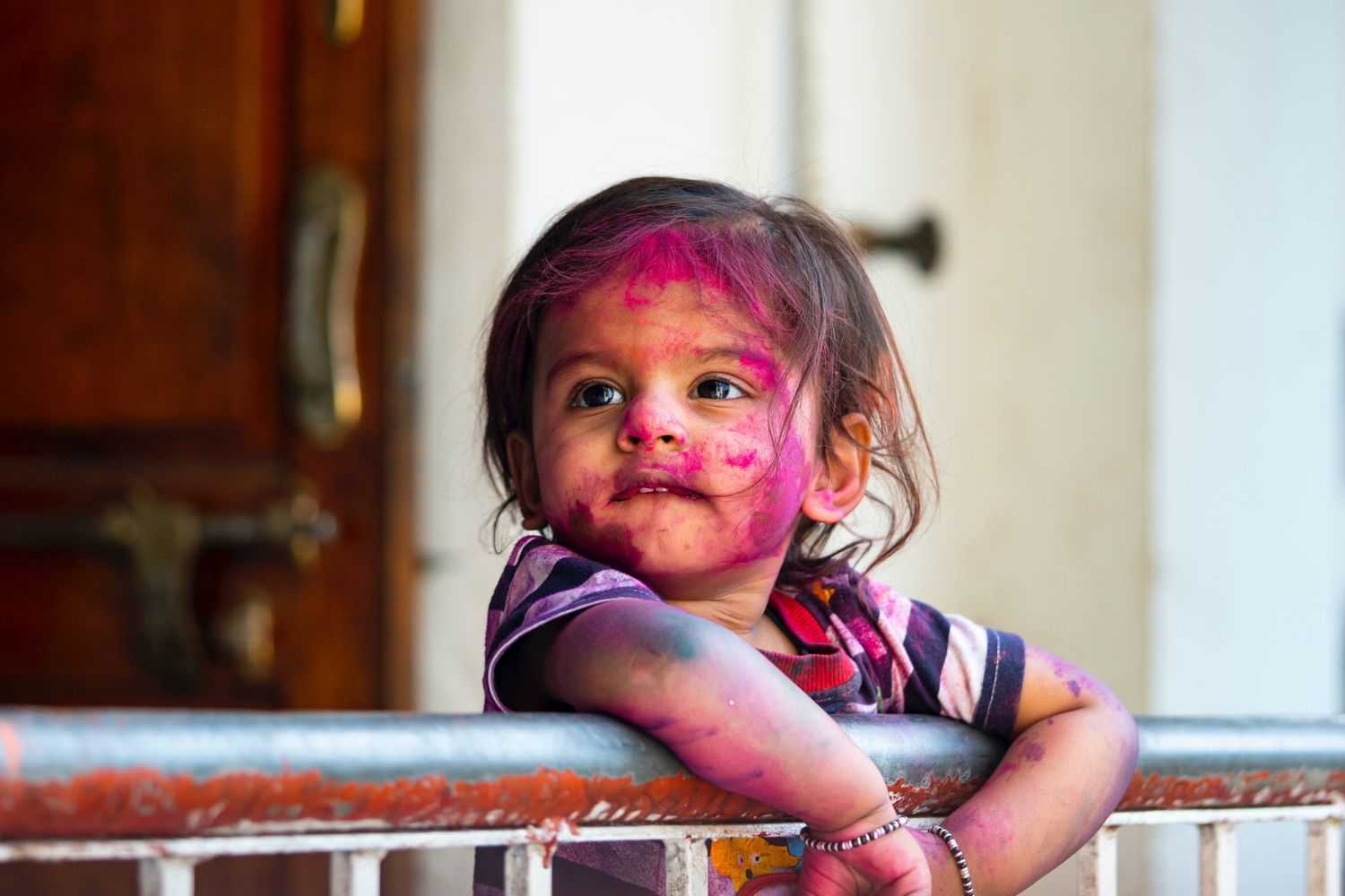 girl on holi makeup leaning on the railing