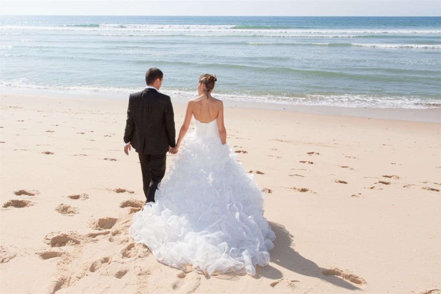 wedding couple walking on beach sands