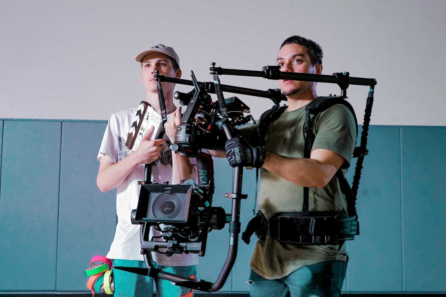 two men hold camera to take vedio
