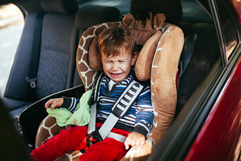 niño llorando en el asiento del auto