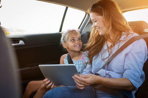 mother and daughter using digital in the car