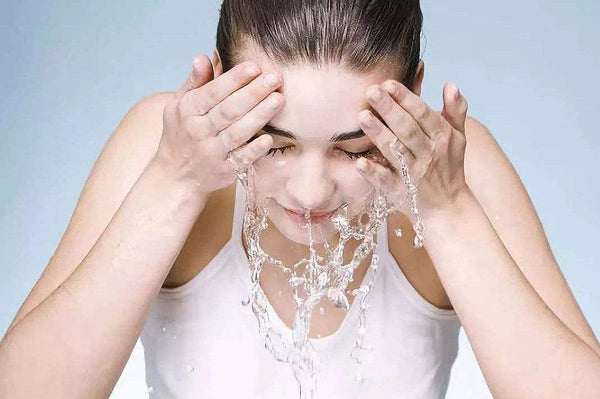 una mujer lavándose la cara